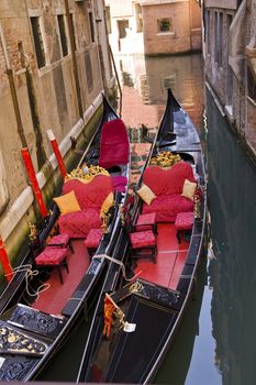 Gondolas moored in a narrow canal in Venice Italy