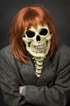 The person in a mask of death from latex and a red wig