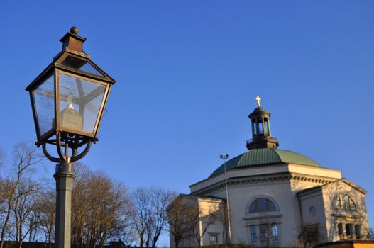 A lamp pole and the Carl Johans church at Skeppsholmen, Stockholm.