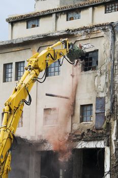 Machinery working to demolish old building