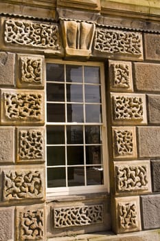 Detail of Victorian age window set in ornate sandstone wall