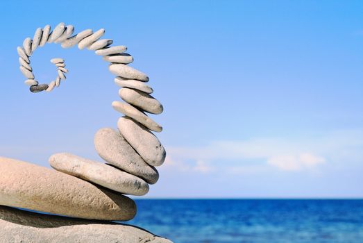 Sea pebble in the form of a spiral in the summer morning on a beach