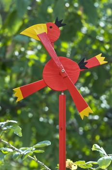 Red bird weather vane against the green