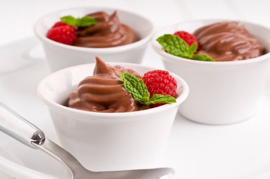 Creamy chocolate pudding with raspberries and mint.