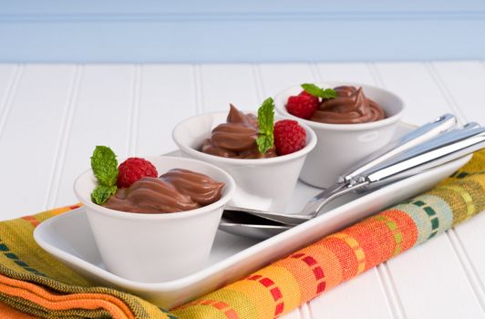 Small cups filled with creamy chocolate pudding.