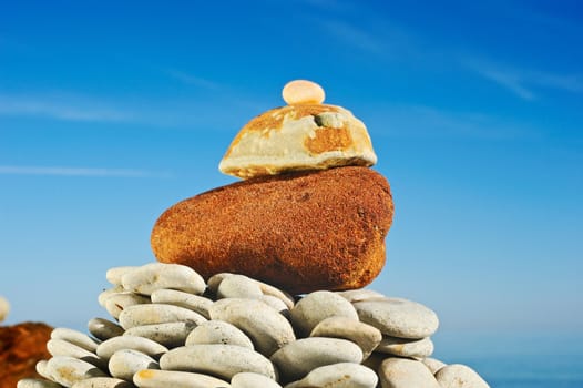 The big red stone at top of a pyramid at the sea in the summer