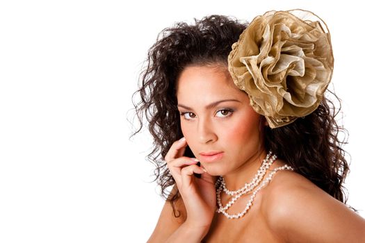 Beautiful face of a Caucasian Hispanic woman with clear skin, wearing a pearl necklace and a fake flower in curly hair, isolated.