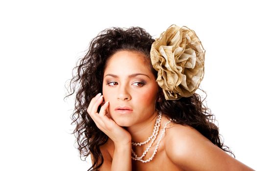 Beautiful face of a tanned Caucasian Hispanic woman with clear skin, wearing a pearl necklace and a fake flower in curly hair, isolated.