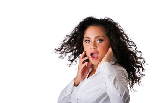 Surprised beautiful Caucasian Hispanic Latina young business woman with brown curley hair. Cute tanned brunette, ethnic girl in white shirt and twirling hair and open mouth, isolated.