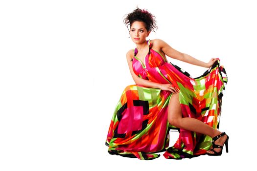 Beautiful Caucasian Hispanic Latina fashion model woman wearing colorful dress, sitting, isolated.