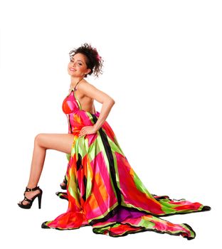 Beautiful sexy Caucasian Hispanic Latina fashion model woman wearing colorful dress, sitting showing leg, isolated.