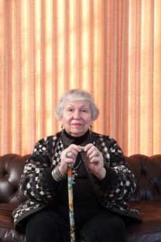 86 year old woman at home,  on sofa, curtain behind