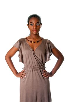 Beatiful African American business woman standing with hands on hips wearing a gray fashion dress and amber necklace, isolated.