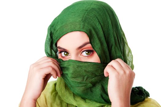 Portrait of mysterious beautiful Caucasian Hispanic Latina woman face with green penetrating eyes and holding green fashion scarf with hands in front of mouth and wrapped around head, isolated.