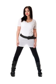 Beautiful brunette Caucasian Hispanic Latina woman with red lipstick standing with legs spread, wearing white shirt, black leggings and belt, isolated.