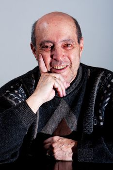 Face of an old man with little hair and bald spot and hand on his chin with happy smiling expression, isolated.