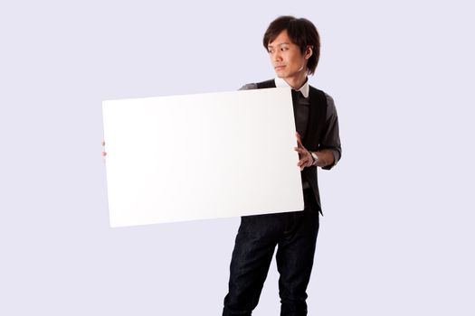 Young Asian business student man standing holding a white blank board and looking at it, isolated.