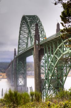 Old green metal bridge disappearing into the mist