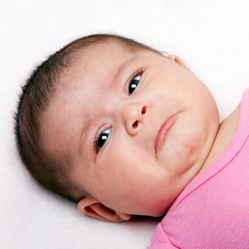 Cute baby with sad expression. Infant with curled lip making faces.