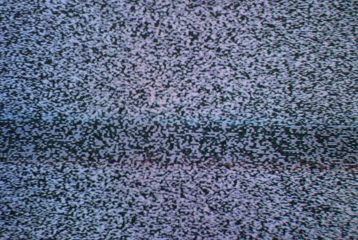 A macro of a T.V. with nothing but static on the screen.