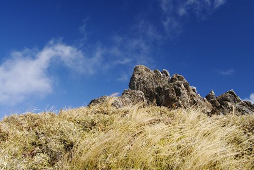 This is taken in Taiwan National Park a blue sky with white clouds and gray rock.