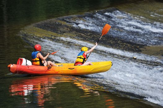 two young adults kayaking on the herault river 