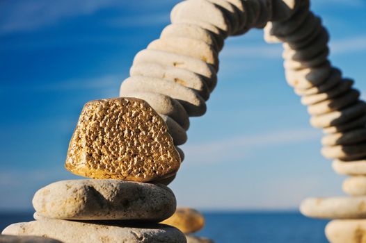 Gold stone near to the big stone arch on a beach