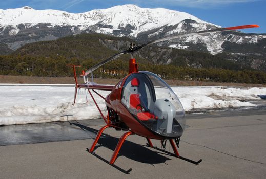 light orange helicopter in stationary . Barcelonnette, France, sky station, in the france.