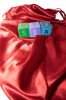 sex written with blocks on a silk nightie against white background