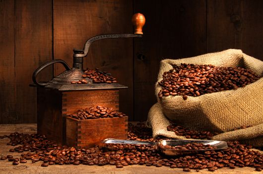 Antique coffee grinder with beans in burlap sack