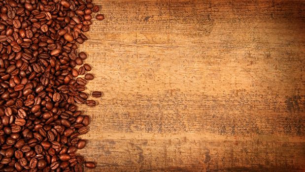 Roasted coffee beans on rustic wood background