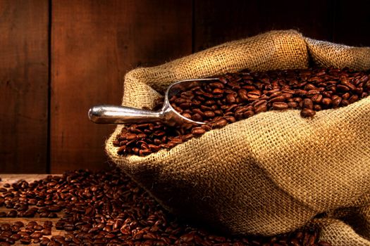 Coffee beans in burlap sack with antique wood background