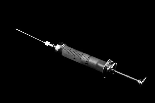 Reusable syringe on a black background on the diagonal