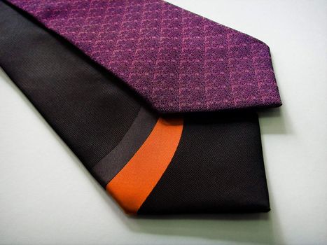 A black and a purple tie on a white background