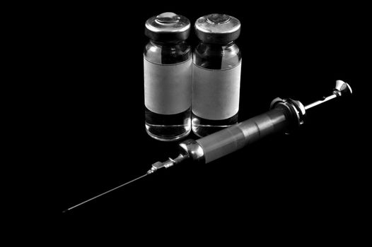Reusable syringe and medicaments on a black background on the diagonal