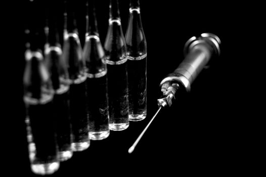 Reusable syringe and ampoules on a black background 