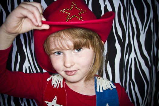 Young girl dressed up in cowgirl outfit.