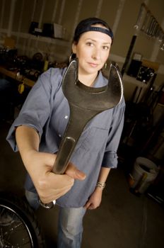 Hispanic woman in a garage with wrench