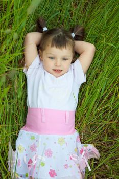 The little girl has a rest in a grass