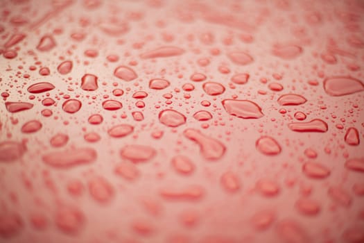 Abstract background - water drops on a surface of red plastic