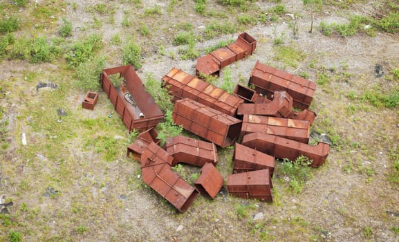 Heap of rusty iron garbage on a green grass