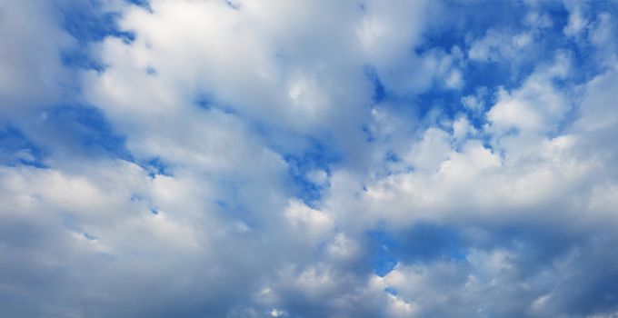 White cumulus clouds in the summer blue sky