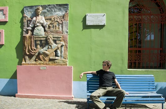 Tourist relaxing on a bench in El Caminito, in el Barrio de La Boca.