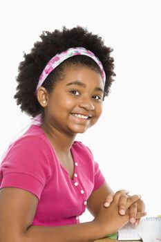 African American girl sitting in school desk smiling at viewer.