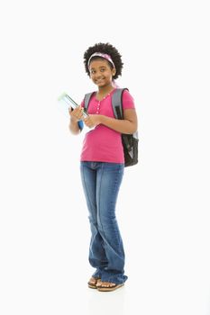 African American girl holding books and wearing backpack smiling at viewer.