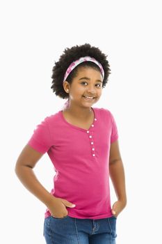 African American girl with hands in pockets wearing headband smiling at viewer.