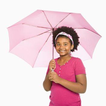 African American girl holding pink umbrella smiling at viewer.