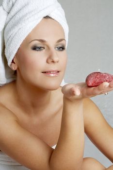 lovely woman with red candle in spa salon