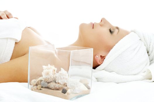 beautiful lady in spa salon with sea shells in glass cube
