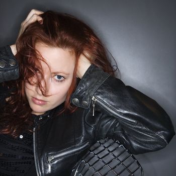 Portrait of pretty redhead young woman holding hands to head.